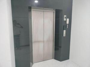 een badkamer met een douche en een houten deur bij โรงแรมนราพัตรา in Narathiwat