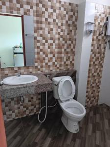 y baño con aseo, lavabo y espejo. en โรงแรมนราพัตรา, en Narathiwat