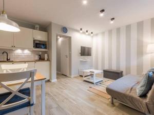 a kitchen and a living room with a couch and a table at Apartamenty Żarnowska in Żarnowska