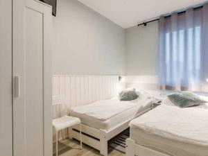 a room with two beds and a chair and a window at Apartamenty Żarnowska in Żarnowska