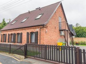 a brick house with a black fence in front of it at Apartamenty Żarnowska in Żarnowska +7 photos