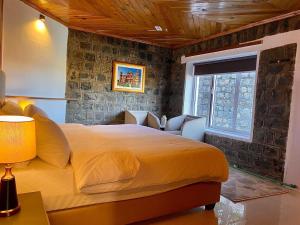 um quarto com uma cama grande e uma janela em Vintage Hut Dunga Gali em Abbottabad
