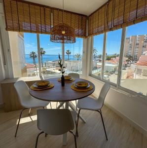 uma sala de jantar com uma mesa e cadeiras com vista para o oceano em Apartment Avril by Spain2home em Torrox Costa