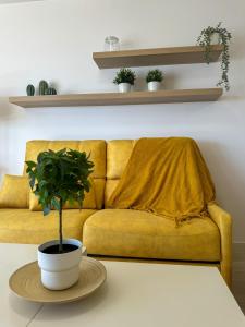 eine gelbe Couch mit einer Pflanze auf dem Tisch in der Unterkunft Apartment Avril by Spain2home in Torrox Costa