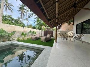 an outdoor patio with a table and chairs and a pool at Villa Eukene - One Bedroom Private Villa in Kuta Lombok