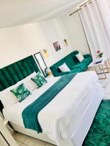 a bedroom with a large bed with a green headboard at City junction studio apartment in Windhoek