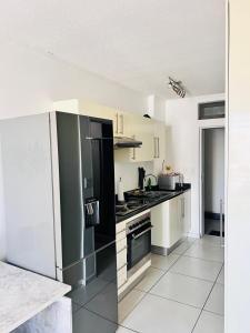 Il comprend une cuisine équipée d'un réfrigérateur et d'une cuisinière. four supérieur dans l'établissement City junction studio apartment, à Windhoek