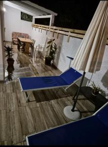 un soggiorno con divano, sedia e ombrellone di That's amore Brindisi beach a Brindisi