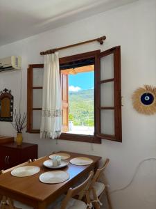 a dining room with a table and a window at Sofia’s Studio in Arnítha