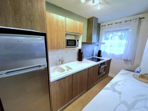 a kitchen with a sink and a refrigerator at Appart Cosy tt confort - Sceaux - 20mn de Paris in Sceaux