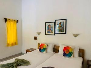 a white couch with flowers on it in a room at Cavala The Seaside Resort, Baga in Baga