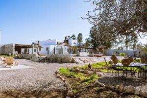 a patio with chairs and a table in front of a house at Villa Madame Babouche, chambre Tanirt, SdB privative in Oulad el Madani
