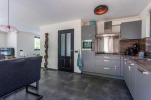 eine Küche mit weißen Schränken und einer schwarzen Tür in der Unterkunft La casa Pacha Mama Sauna en Hottub in Ewijk