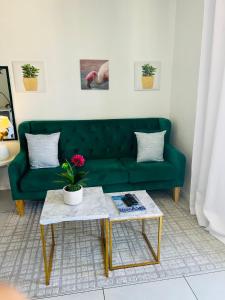 a green couch in a living room with a table at City junction studio apartment in Windhoek