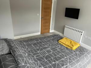 a bedroom with a bed with a yellow blanket on it at 1 bedroom ground floor apartment in Southbourne