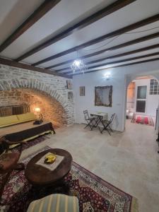 sala de estar con chimenea de piedra y mesa en Villa Olive Old Qeparo, en Qeparo