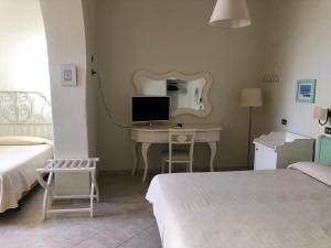 a bedroom with a desk with a computer and a mirror at Hotel Dania in Sorrento