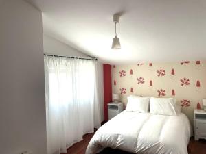 a bedroom with a white bed and a window at Puebla :) in A Pobra do Caramiñal