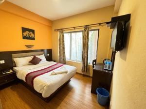 Schlafzimmer mit einem Bett und einem Flachbild-TV in der Unterkunft Hotel Namtso in Kathmandu
