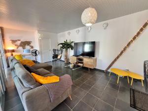 a living room with a couch and a tv at BEACHFRONT Diamond Rock - Guest Suite with breakfast area OR Entire Apartment in Le Diamant