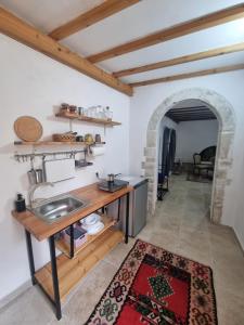 a kitchen with a table and a sink in a room at Villa Olive Old Qeparo in Qeparo