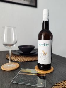 een fles wijn op een tafel naast een glas bij Rota Candor Apartamento in Rota
