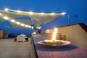 a fire pit on a patio with a white canopy at Casa Vacanze Borgata del Sorbo in Acireale