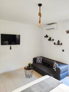 een woonkamer met een blauwe bank en een tv bij Rota Candor Apartamento in Rota