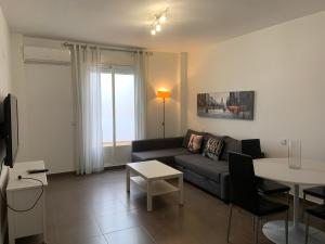 una sala de estar con un sofá y una mesa en APARTAMENTO JALAMA 1B, en Moraleja