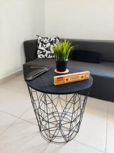 een zwarte tafel met een plant en twee dozen erop bij Rota Candor Apartamento in Rota