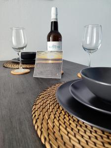 een fles wijn en twee glazen op een tafel bij Rota Candor Apartamento in Rota