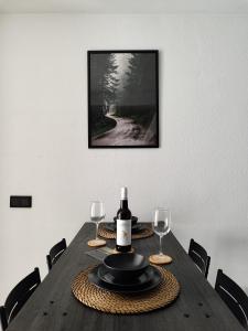 una mesa con una botella de vino y dos copas de vino en ESCAPADAS ROMÁNTICAS Gavira Apartamento, en Rota