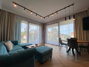 Niechorze - Par La Mer 6A في نيخوجة: غرفة معيشة مع أريكة زرقاء وطاولة