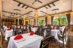 a restaurant with white tables and chairs with red napkins at Thuong Trang Villa Phu Quoc in Phu Quoc
