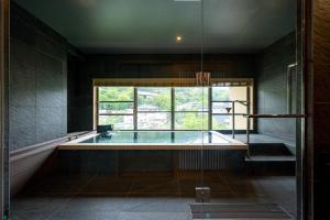 a large swimming pool in a room with a window at Hakone Yumoto Onsen Hotel Kajikaso in Hakone