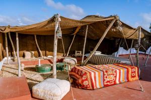 a tent with a bed and two chairs under it at Villa Madame Babouche, Studio Lahna, SdB privative in Oulad el Madani +3 photos