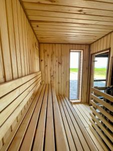uma sauna de madeira vazia com uma janela em Stodoła Na Kresach - widokowy domek drewniany, całoroczny JACUZZI & SAUNA em Bodzentyn