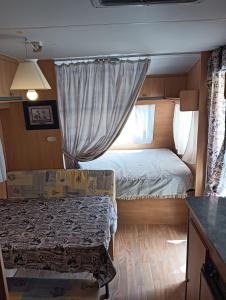 niewielka sypialnia z łóżkiem i oknem w obiekcie Caravana Magic w mieście Tindaya