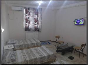 - une chambre avec 2 lits, une table et des chaises dans l'établissement Hostel 1 er novembre khenchela, à Khenchela