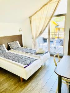 1 dormitorio con 2 camas y balcón en Simono Vila, en Palanga