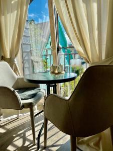mesa y sillas en una habitación con ventana grande en Simono Vila, en Palanga
