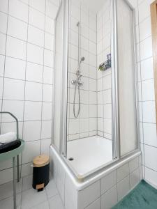 ein weißes Bad mit einer Dusche und einer Badewanne in der Unterkunft Pretty Home City Jungle in Zwickau