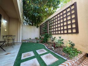 un patio con un prato verde di fronte a un edificio di Elegant Studio a Al Fanātīr