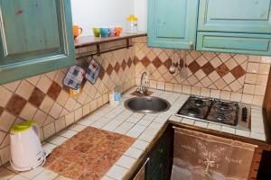 a kitchen with a sink and a stove at Maria Guesthouse in Sassari