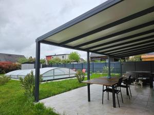 a pavilion with a table and chairs on a patio at Idéal 24H voiture, moto, camion in Mulsanne