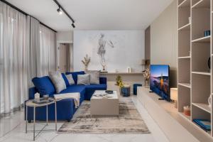 een woonkamer met een blauwe bank en een tafel bij Abau Residence Apartment 2 Opatija in Opatija