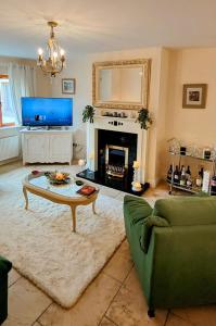 sala de estar con sofá verde y chimenea en Lough Rynn, en Mohill