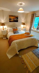 ein Schlafzimmer mit einem großen Bett mit einer orangefarbenen Decke in der Unterkunft Lough Rynn in Mohill