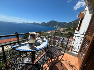 a balcony with a table with two cups on it at La dimora degli Dei in Praiano