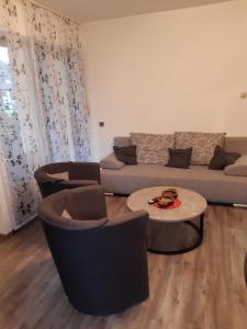 sala de estar con sofá, sillas y mesa en Ferienwohnung Mörchen, en Winterberg